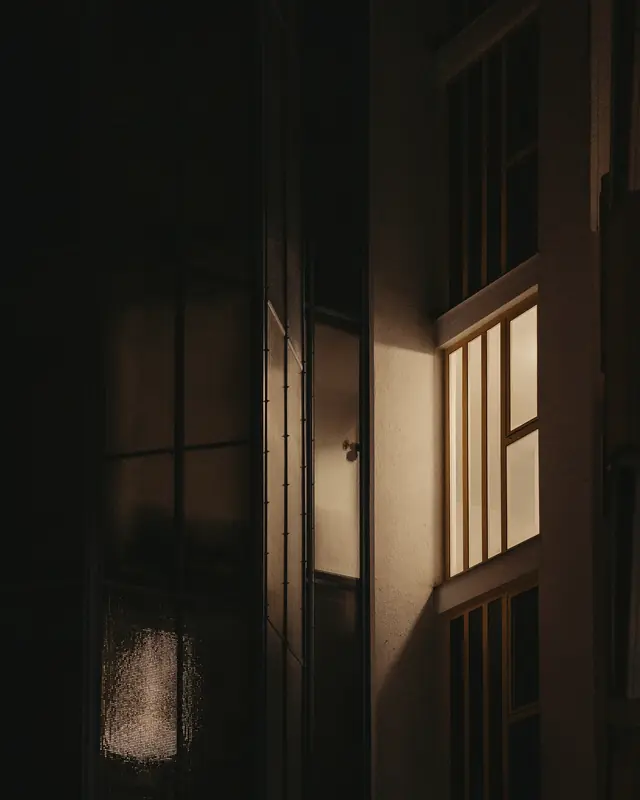 One lit window in a dark building at night.